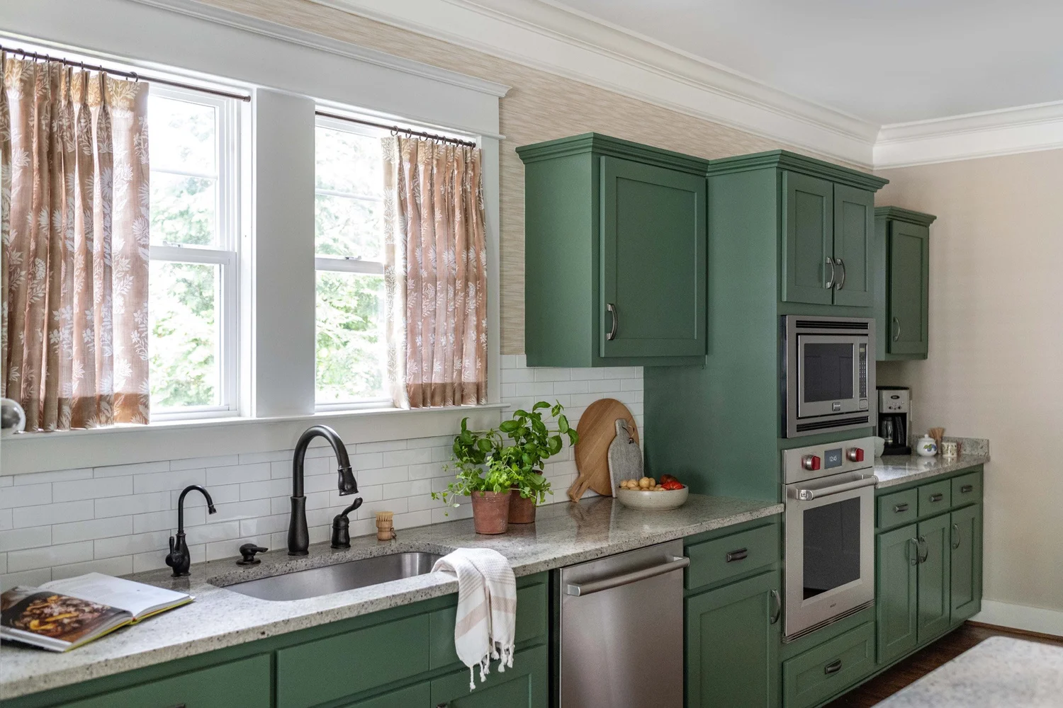 A white kitchen with a marble island, brass hardware and a tiled backsplash