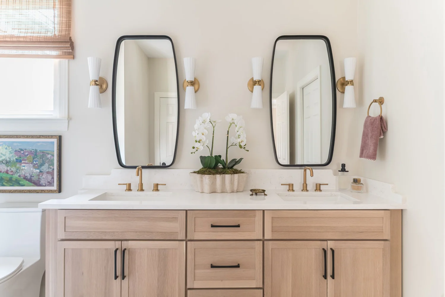 A primary bathroom with a freestanding tub, marble tile and a large mirror